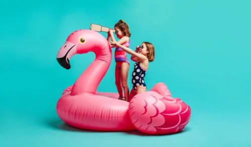 Cute girls in swimwear playing on inflatable mattress